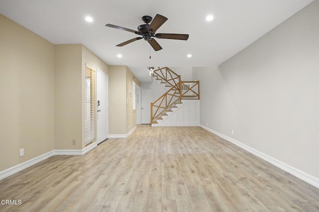 unfurnished living room featuring a ceiling fan, baseboards, recessed lighting, stairs, and light wood-style floors