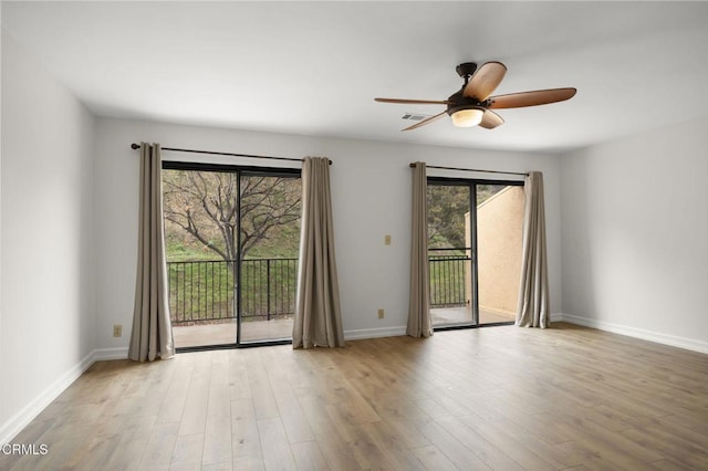 empty room featuring visible vents, wood finished floors, baseboards, and ceiling fan