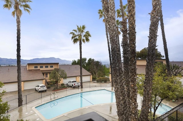 pool with a mountain view, a patio, and fence