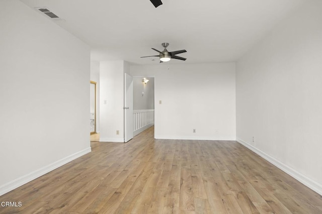 empty room with light wood finished floors, visible vents, baseboards, and ceiling fan