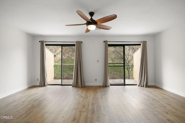 spare room featuring a healthy amount of sunlight, a ceiling fan, baseboards, and wood finished floors