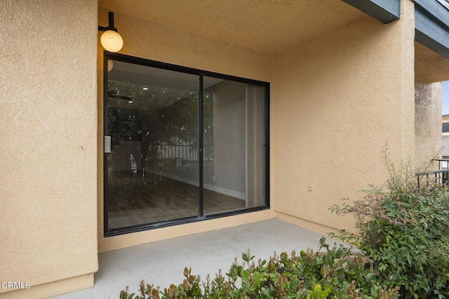 view of exterior entry featuring stucco siding