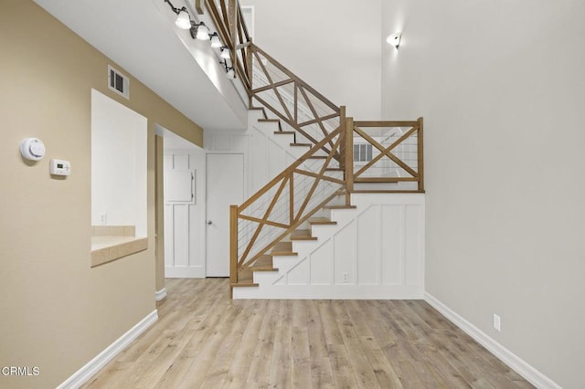 staircase featuring visible vents, baseboards, and wood finished floors