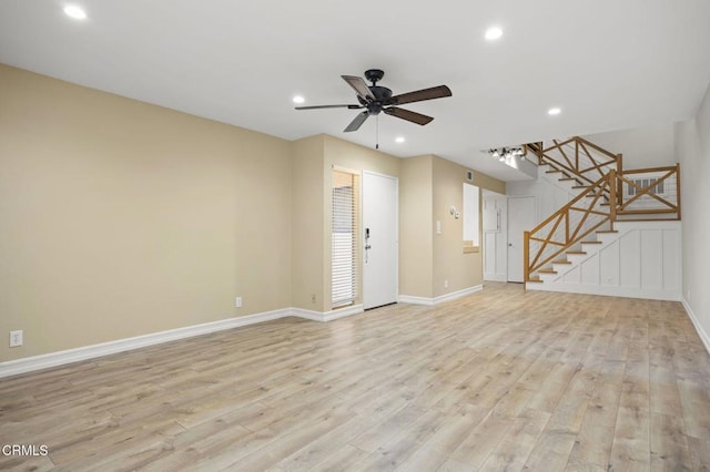 unfurnished living room with baseboards, light wood-style flooring, recessed lighting, ceiling fan, and stairs