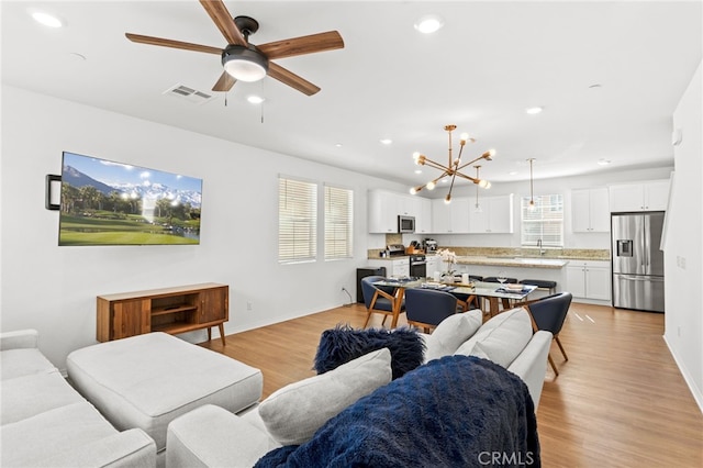 living room featuring recessed lighting, visible vents, baseboards, and light wood finished floors