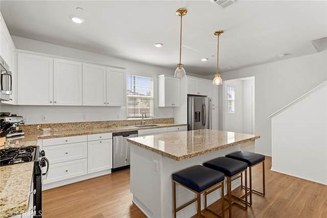 kitchen with white cabinetry, light wood-style flooring, appliances with stainless steel finishes, and a sink