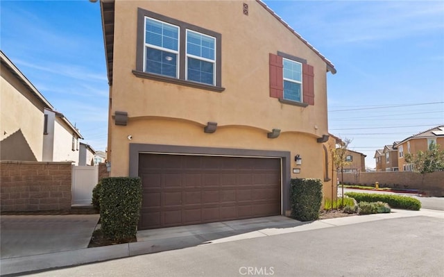 view of front of home with fence and stucco siding