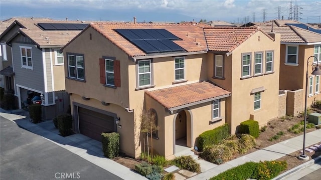 view of front of house with stucco siding, solar panels, and a tile roof