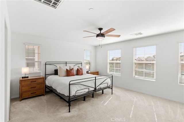 bedroom featuring ceiling fan, baseboards, visible vents, and light carpet