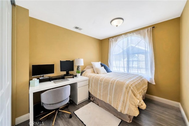 bedroom with dark wood finished floors, visible vents, and baseboards