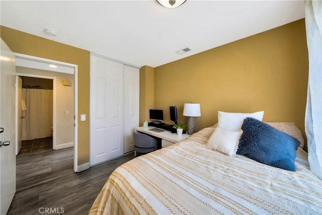 bedroom with visible vents, baseboards, a closet, and dark wood-style floors