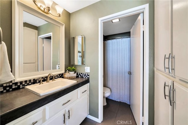 bathroom with a shower with shower curtain, decorative backsplash, toilet, and vanity