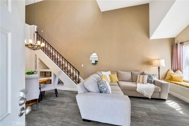 living room with baseboards, stairway, wood finished floors, a notable chandelier, and high vaulted ceiling