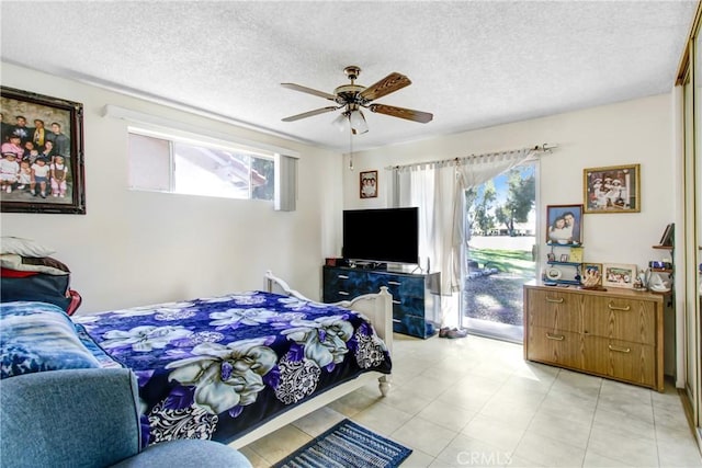 bedroom featuring multiple windows, a textured ceiling, and access to outside