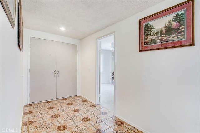 entrance foyer featuring light floors, baseboards, and a textured ceiling