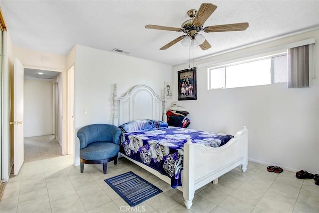 bedroom featuring light tile patterned floors, a ceiling fan, visible vents, and baseboards