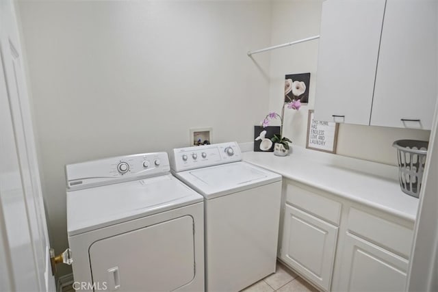 clothes washing area with light tile patterned floors, cabinet space, and separate washer and dryer