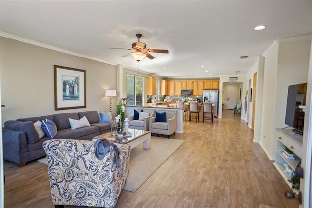 living area with visible vents, ceiling fan, light wood-type flooring, ornamental molding, and recessed lighting