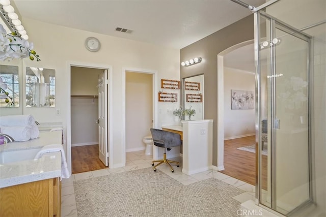 bathroom with visible vents, toilet, a stall shower, tile patterned flooring, and vanity