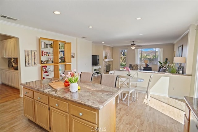 kitchen with open floor plan, light wood-style flooring, and a fireplace