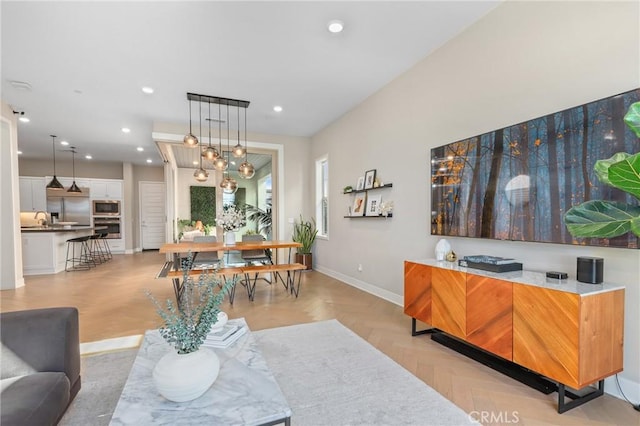 living area with recessed lighting, baseboards, and a notable chandelier