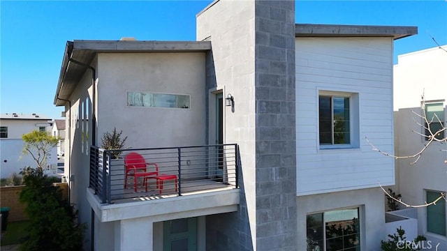 exterior space with stucco siding and a balcony