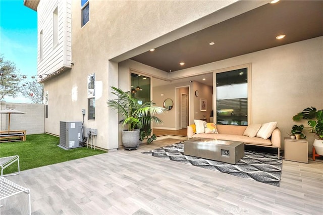 view of patio / terrace with cooling unit and an outdoor living space with a fire pit