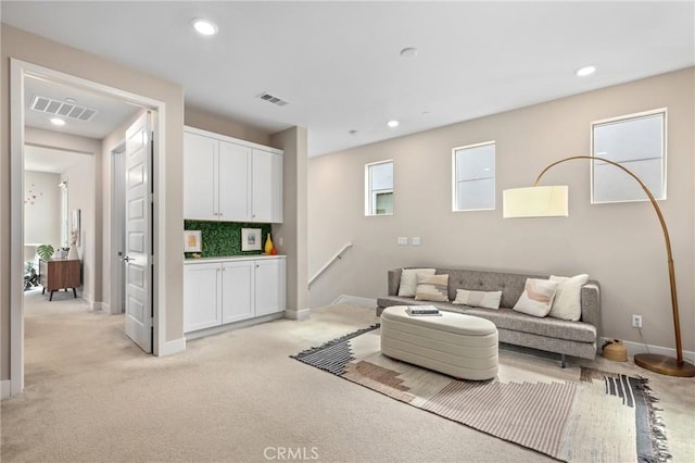 living area with recessed lighting, visible vents, and baseboards