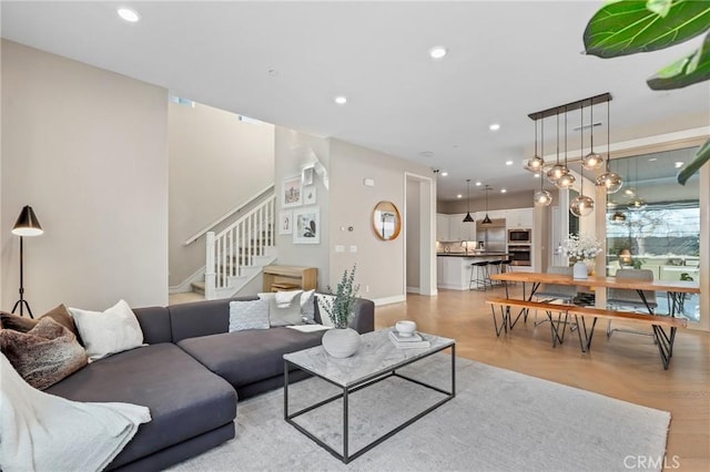 living room featuring stairway, recessed lighting, and baseboards