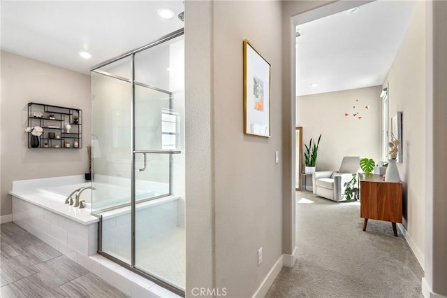 full bathroom featuring a bath, baseboards, and a stall shower