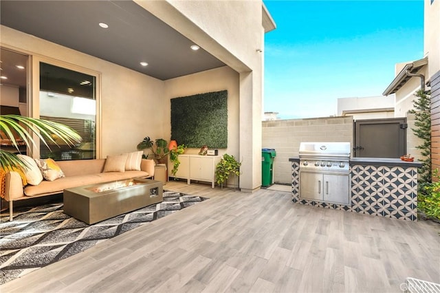 view of patio featuring area for grilling, an outdoor living space with a fire pit, and fence