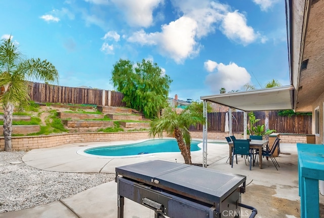 view of pool with a fenced in pool, a fenced backyard, outdoor dining space, and a patio area