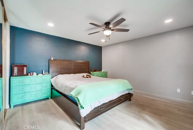 bedroom with a ceiling fan, wood finished floors, baseboards, recessed lighting, and a textured wall