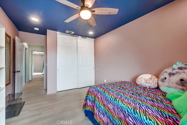 bedroom with a closet, visible vents, light wood-style flooring, and recessed lighting