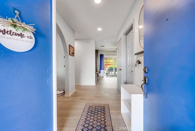 foyer entrance with a ceiling fan, recessed lighting, arched walkways, baseboards, and wood tiled floor