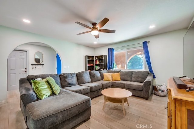 living room featuring recessed lighting, a ceiling fan, and arched walkways