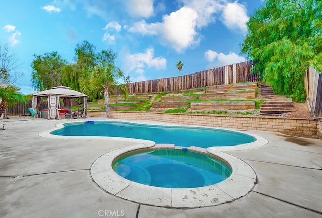 view of swimming pool with a gazebo, a patio, a pool with connected hot tub, and a fenced backyard