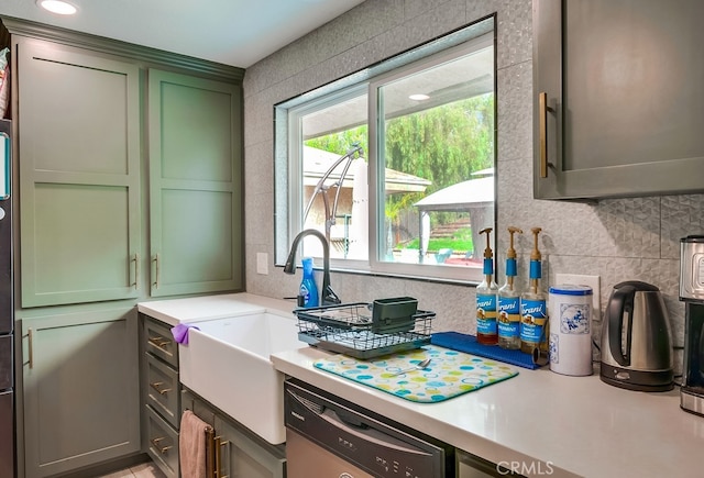 kitchen featuring decorative backsplash, dishwasher, light countertops, and green cabinets