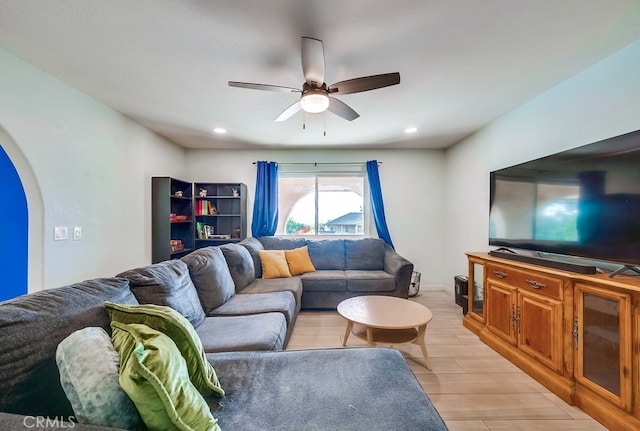 living room featuring arched walkways, recessed lighting, light wood finished floors, and a ceiling fan