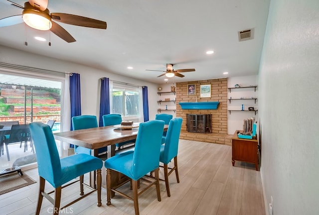 dining space featuring a ceiling fan, visible vents, a fireplace, recessed lighting, and light wood-style floors