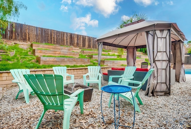 view of patio / terrace with a gazebo, fence, and an outdoor fire pit