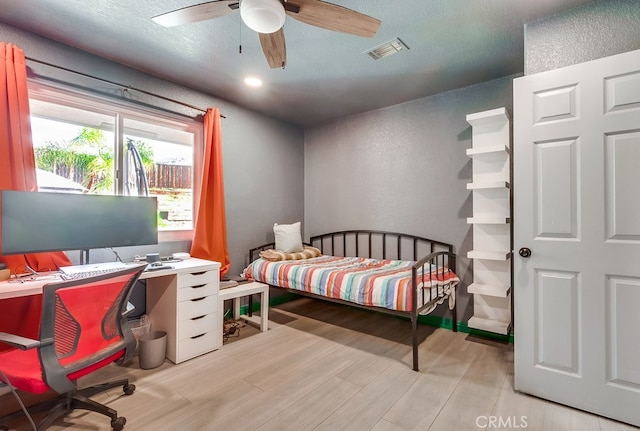 bedroom with visible vents, a textured ceiling, ceiling fan, and wood finished floors