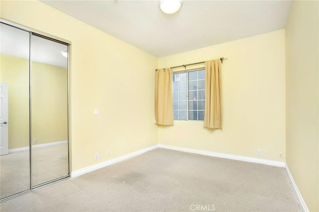 unfurnished bedroom featuring a closet, carpet flooring, and baseboards