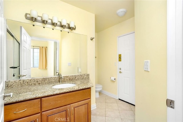 bathroom featuring tile patterned floors, toilet, vanity, and baseboards