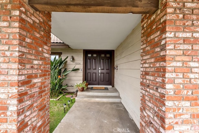 property entrance featuring brick siding