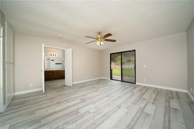 unfurnished bedroom with access to outside, baseboards, light wood-type flooring, and a textured ceiling