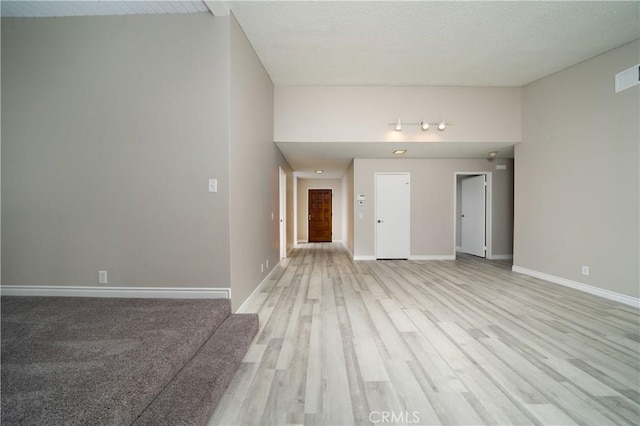 unfurnished living room with light wood finished floors and baseboards