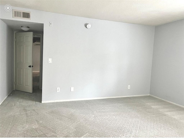 unfurnished room with visible vents, a textured ceiling, baseboards, and carpet floors