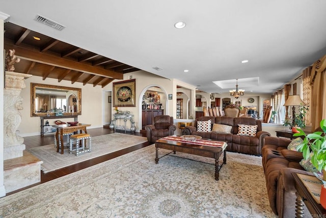 living area featuring visible vents, a chandelier, lofted ceiling with beams, recessed lighting, and wood finished floors