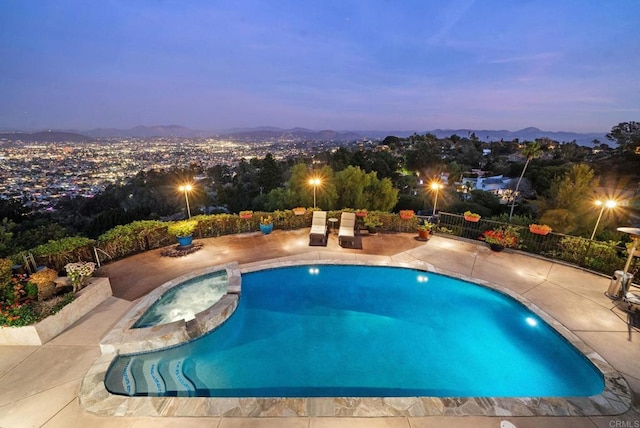 view of swimming pool featuring a patio area, a pool with connected hot tub, and fence